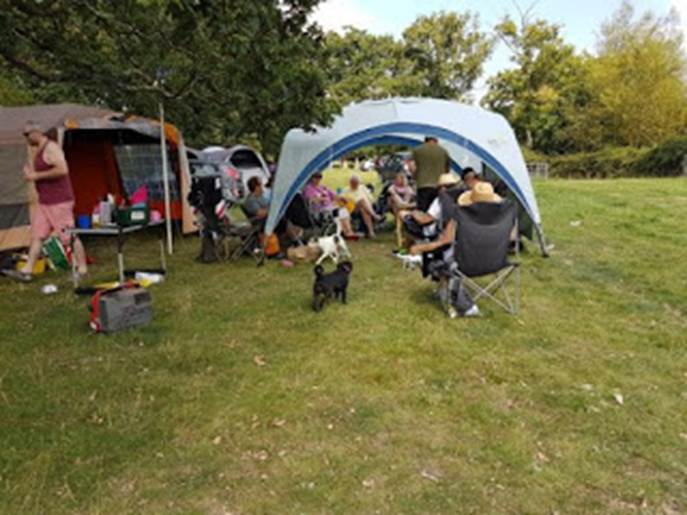 A group of people sitting in chairs under a tent

Description automatically generated